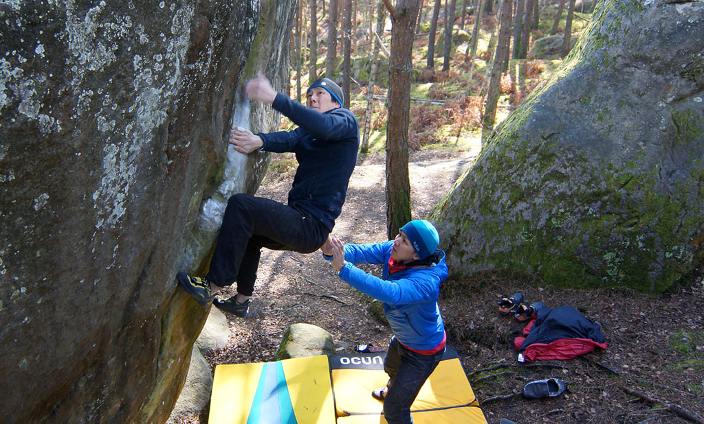 Notice the spotter is 100% focused and ready to spot the hips of the climber and guide him to a safe and upright landing
