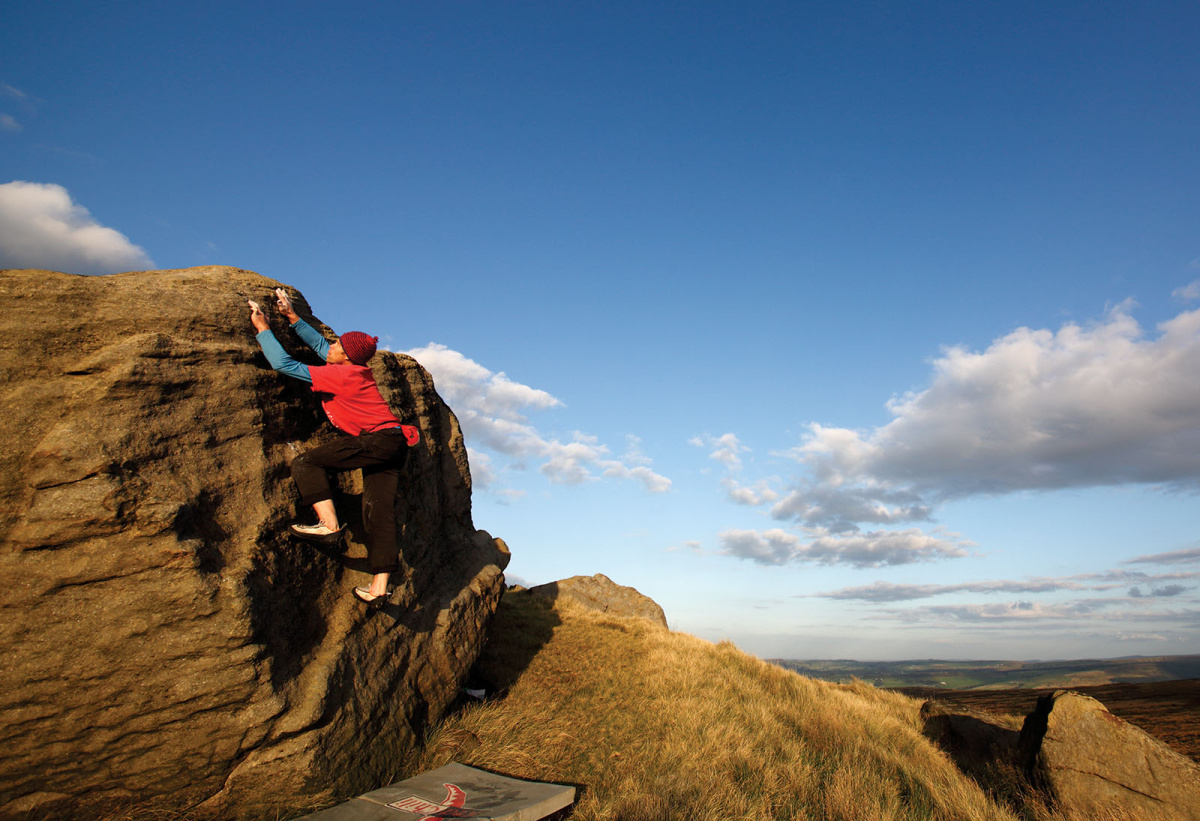 Mike Hutton enjoying the stunning setting and a lovely V0- on the Ramp Boulder close to the trig point. This block has a couple of good problems for beginners and kids alike. Photo: © David Simmonite